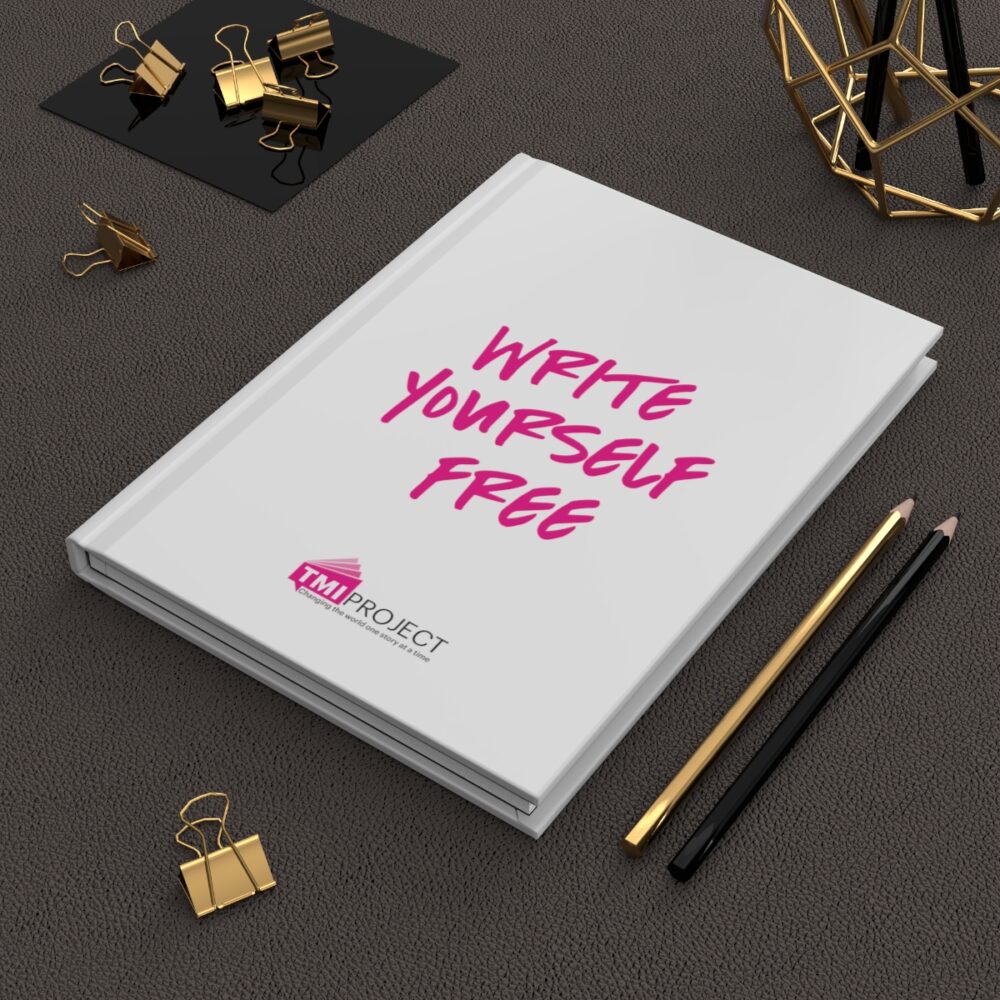 Image of write yourself free TMI Project notebook next to pencils on desk